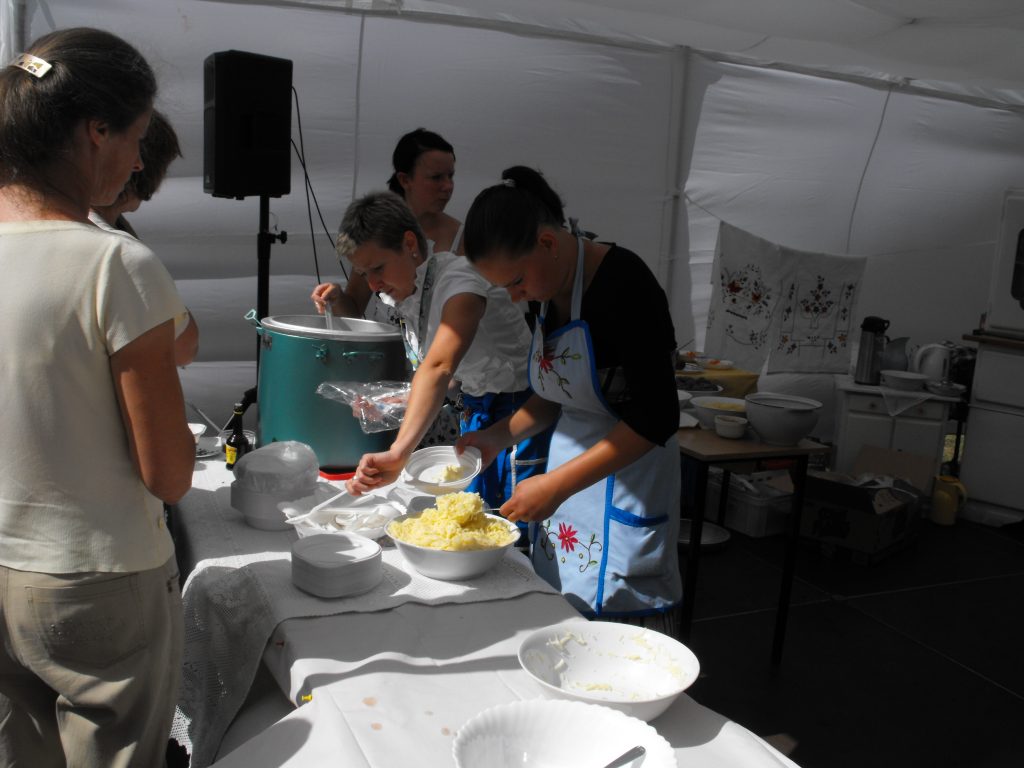 Wnętrze namiotu w kt&oacute;rym trzy kobiety wydają posiłek.