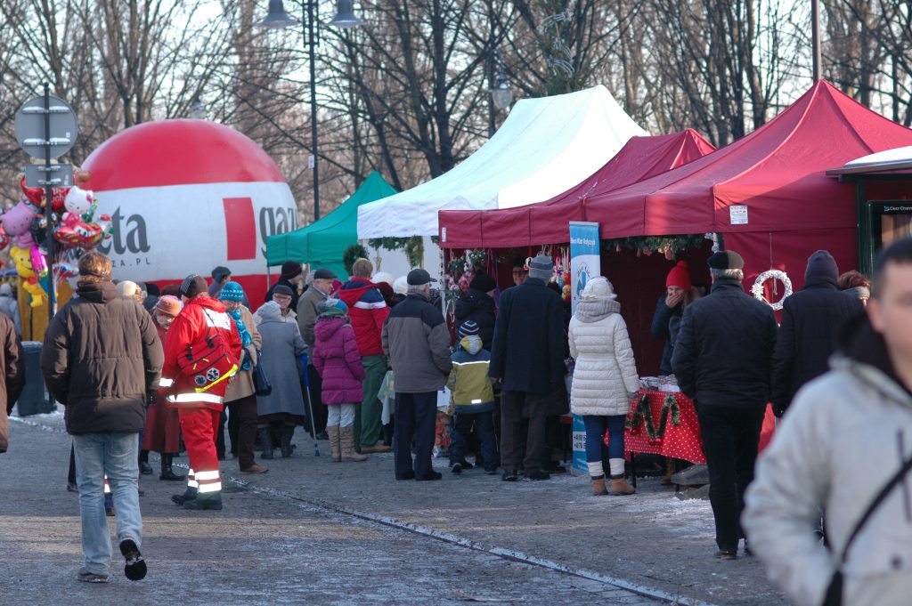 Ludzie pomiędzy stoiskami jarmarku.