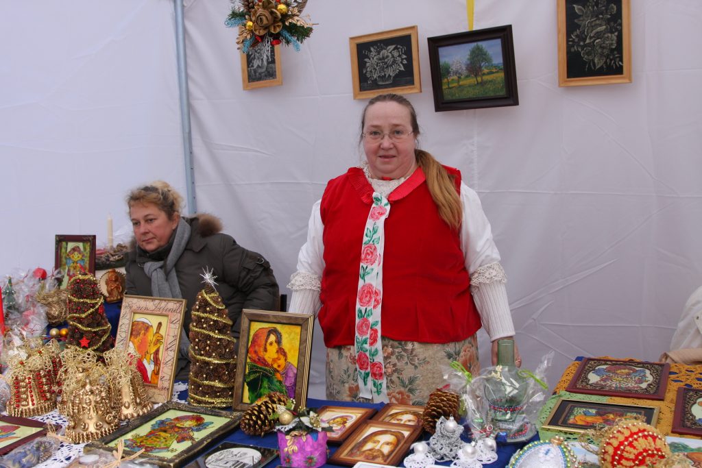 Dwie kobiety przy stoisku z własnoręcznie wykonanymi ozdobami świątecznymi. Jedna z nich ubrana w tradycyjny śląski str&oacute;j ludowy.