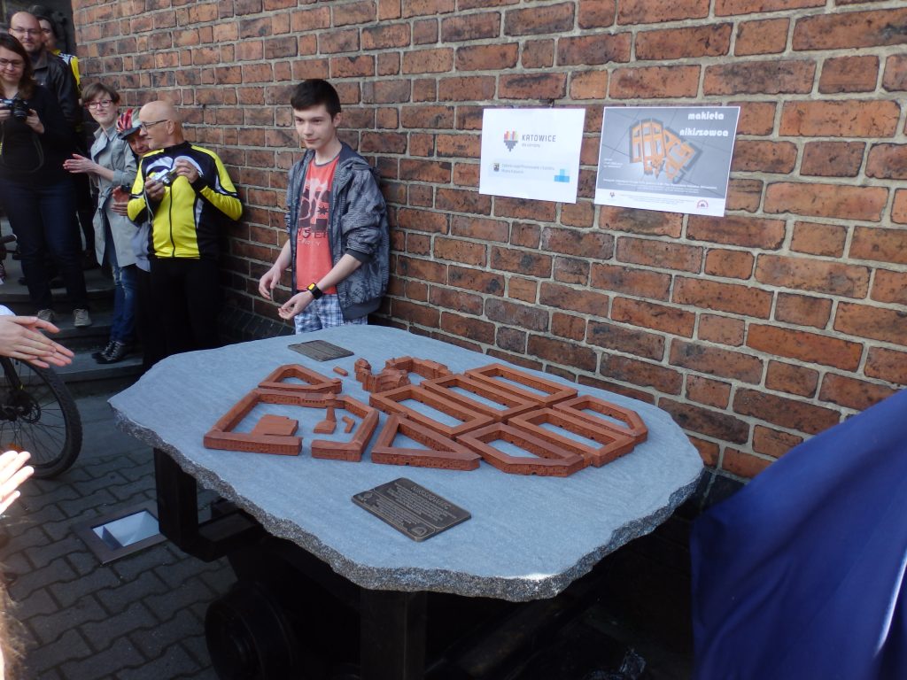 Grupa os&oacute;b przy makiecie dotykowej osiedla Nikiszowiec.