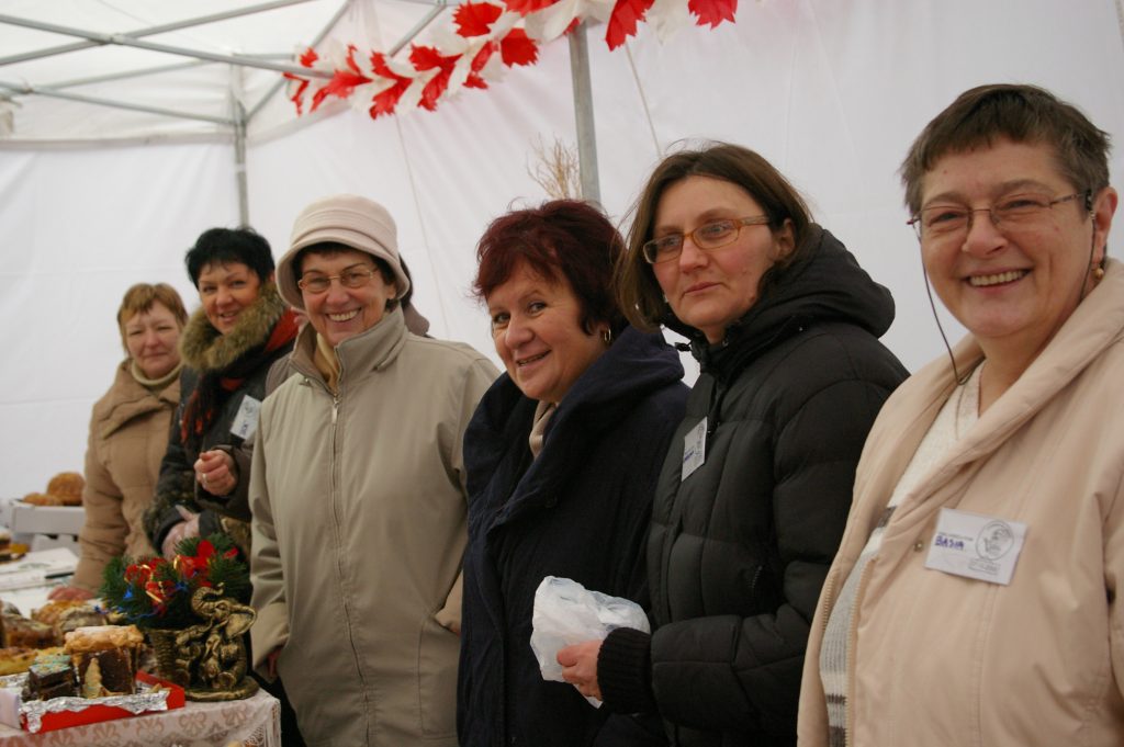 Grupa kobiet sprzedająca wypieki podczas jarmarku.