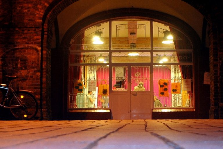 Oświetlona witryna Centrum Zimbardo w Nikiszowcu nocą.