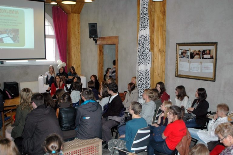 W sali przed rzutnikiem siedzi kilkunastoosobowa grupa młodych os&oacute;b.